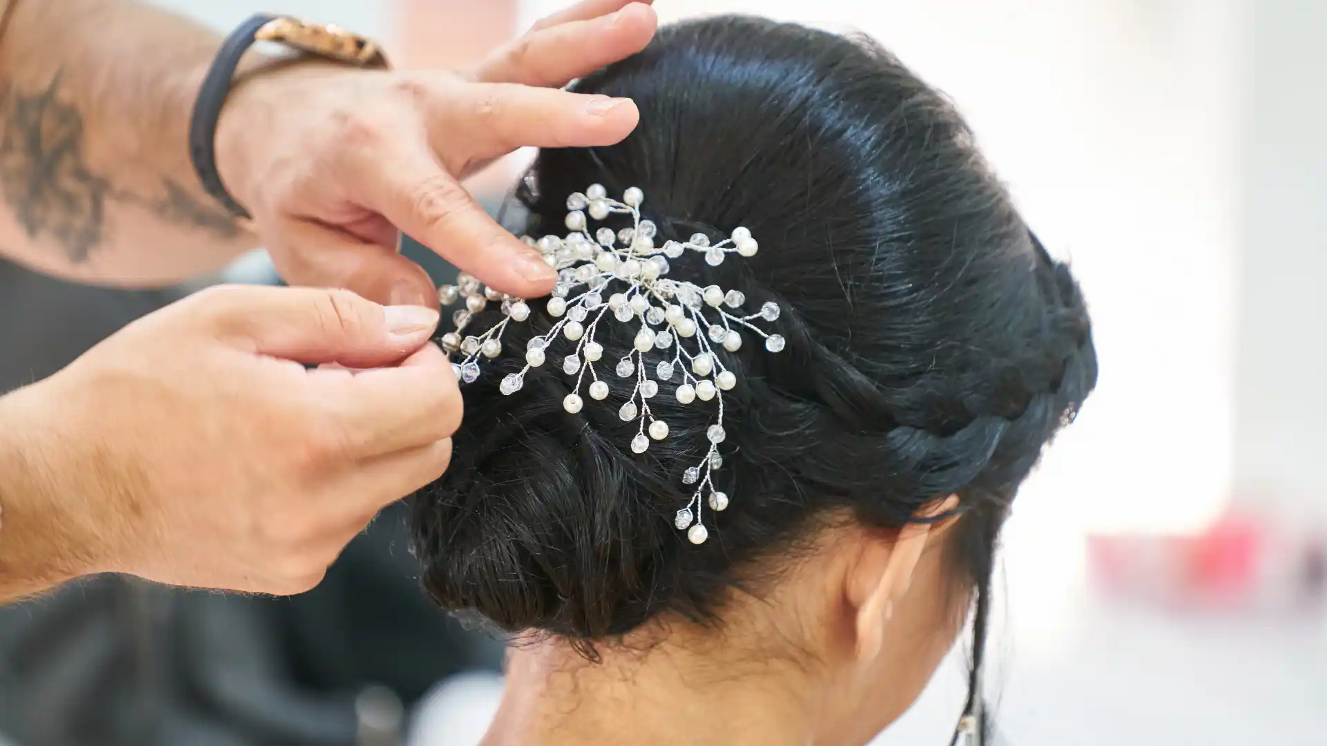 Stylist placing a hair accessory in a woman's updo