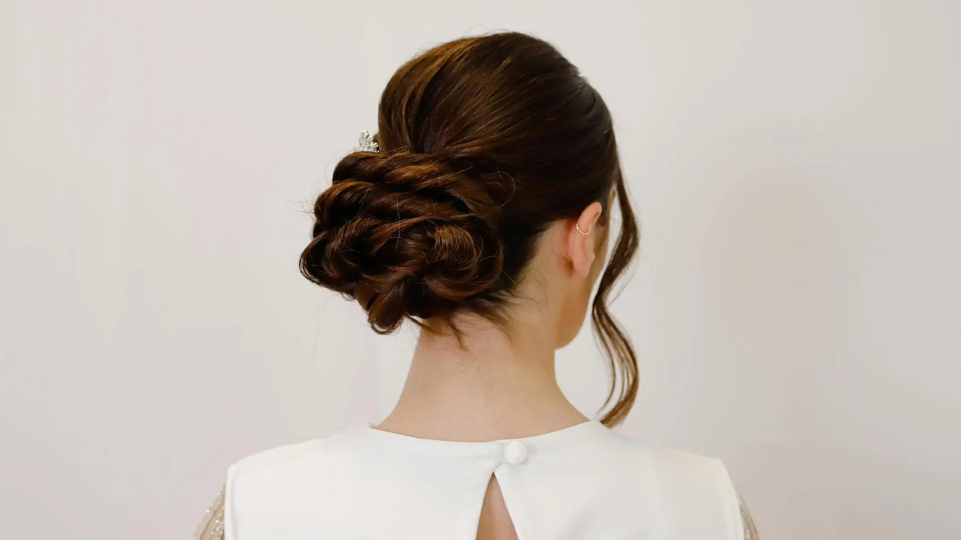 Back view of a woman with an elegant updo hairstyle.